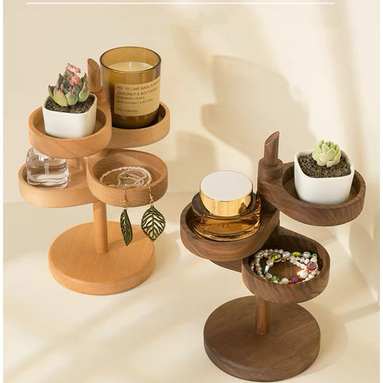 Two wooden jewelry organizers with multiple tiers, styled with small succulent plants, a candle, a perfume bottle, and jewelry, set against a warm beige background with soft shadows.