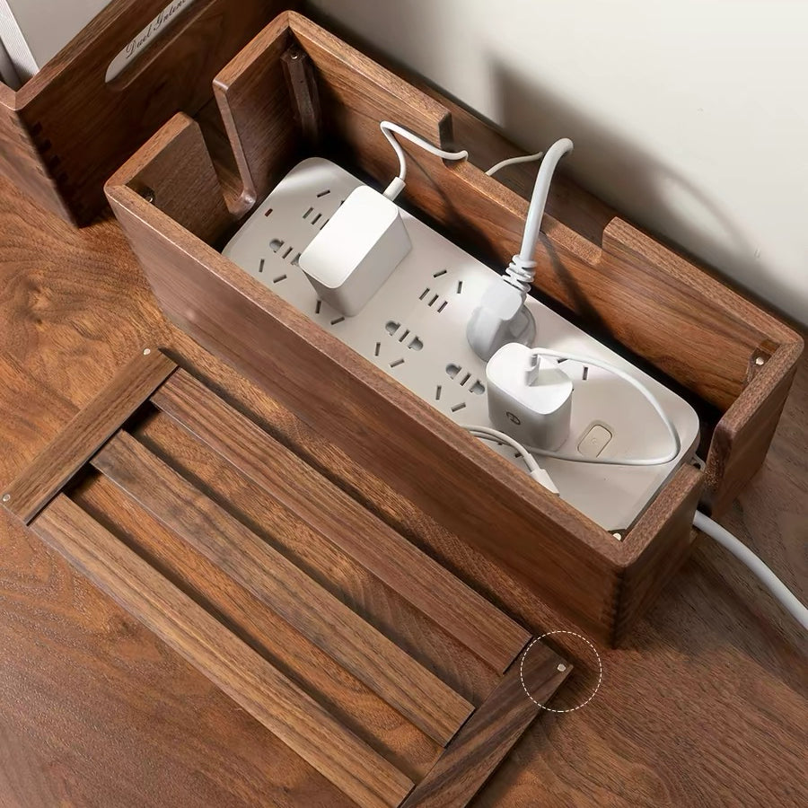A dark brown wooden cable management box with a sliding lid, shown containing a white power strip and various electronic adapters. The main product is the wooden organizer box, with the sliding lid positioned below and to the left.