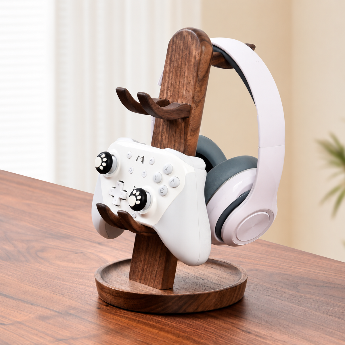 A wooden game controller stand holding a white game controller and a white over-ear headset, placed on a wooden table in a softly lit indoor setting.