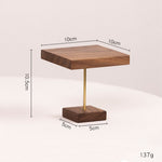 A small wooden side table or display stand with a square dark wood top, a slim gold metal stem, and a rectangular dark wood base. Black dimension lines and text show 10cm top width, 10.