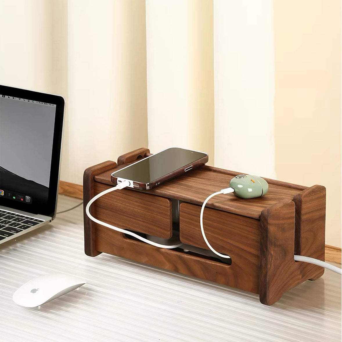 A dark brown wooden desktop organizer with drawers and a top tray, shown on a desk with a laptop, mouse, and phone plugged in. The background features cream-colored vertical blinds.