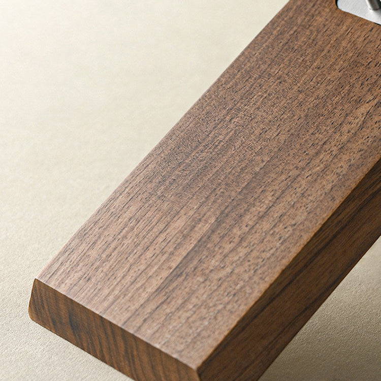 A close-up of a dark brown wooden block with a visible wood grain texture, positioned diagonally on a light beige background.