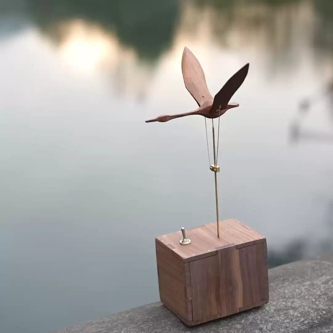 Wooden bird sculpture on a block with a blurred natural background