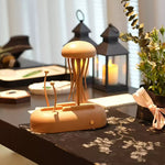 Wooden decorative item on a table with candles and plants in the background