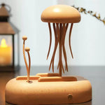 A wooden jellyfish-shaped decorative object with long tentacles on a matching base, displayed on a tabletop with a blurred lantern candle and plant in the background.
