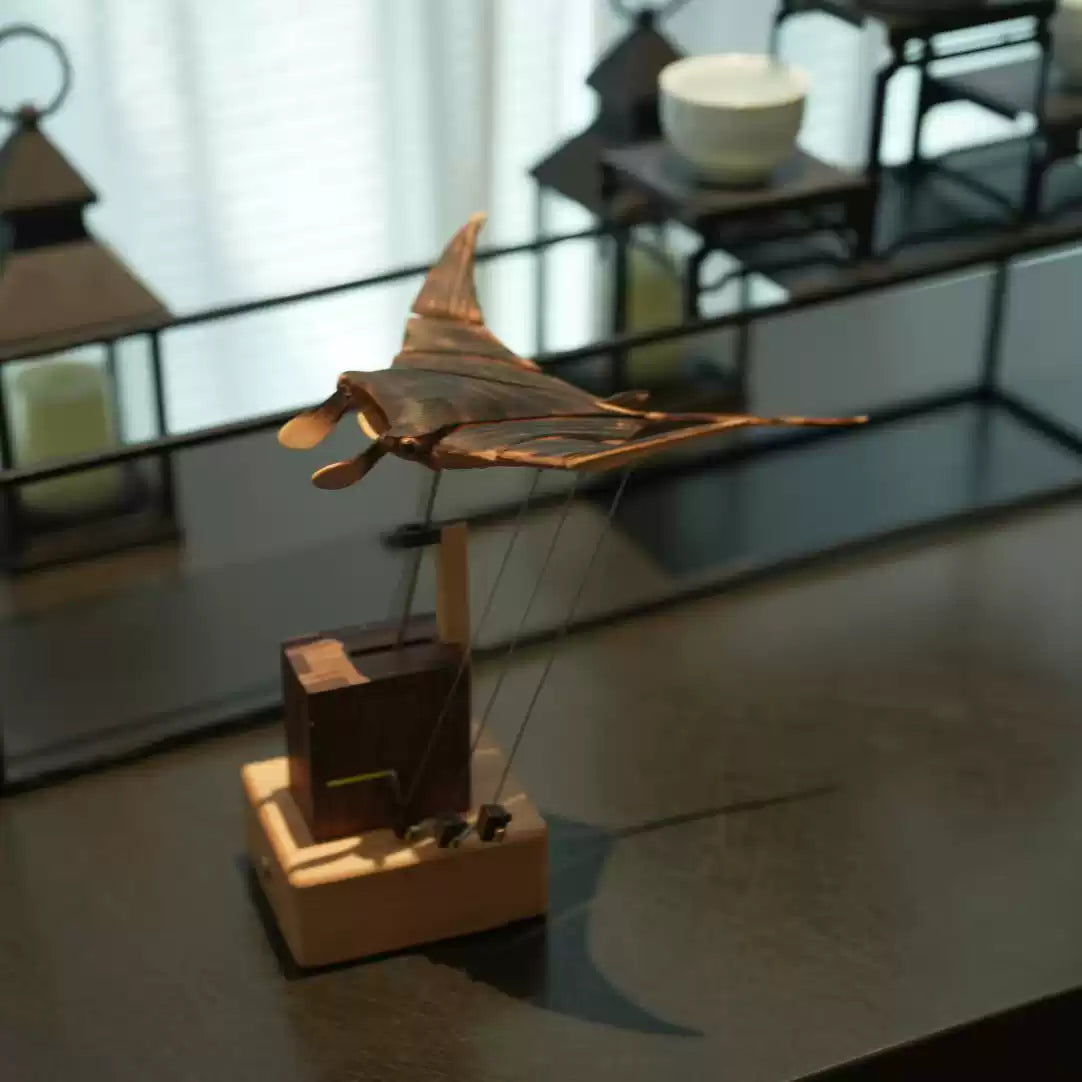 Wooden model of a vintage airplane on a reflective surface with blurred background